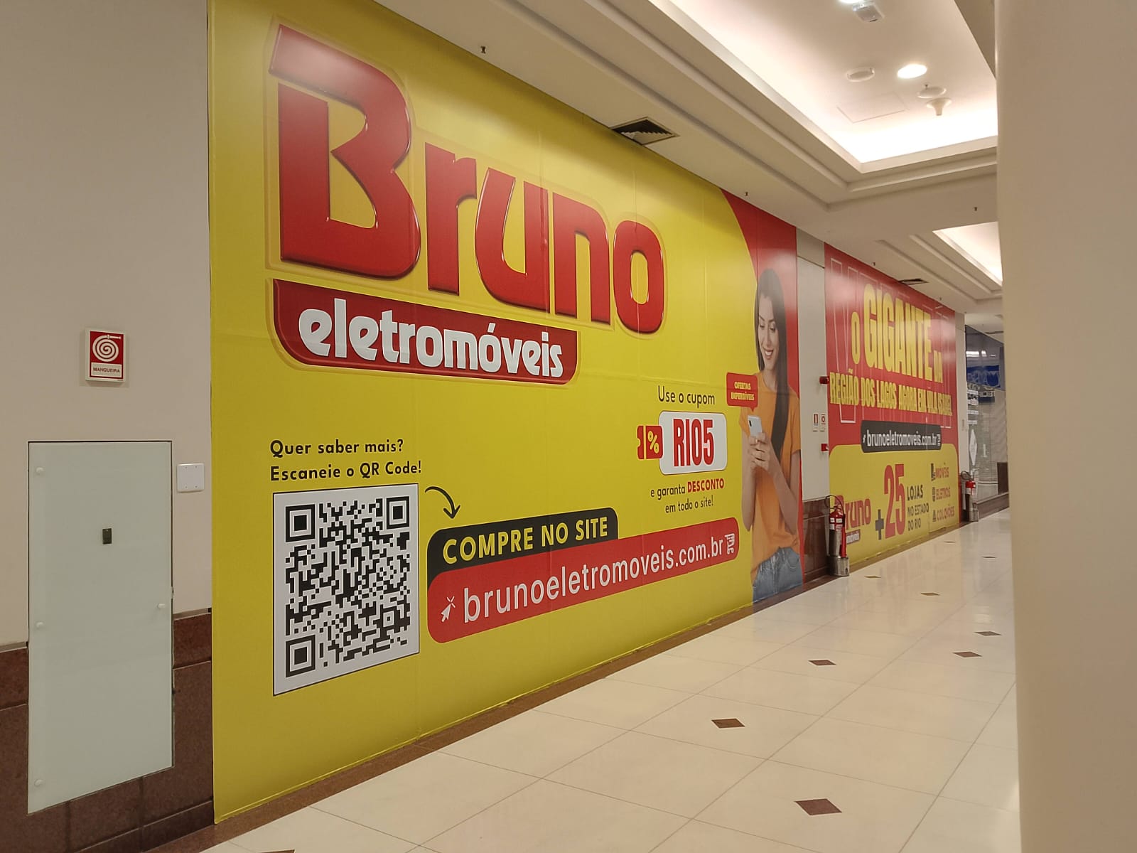Tapume Bruno Eletromóveis — adesivação de fachada de loja em shopping com logotipo em grande formato