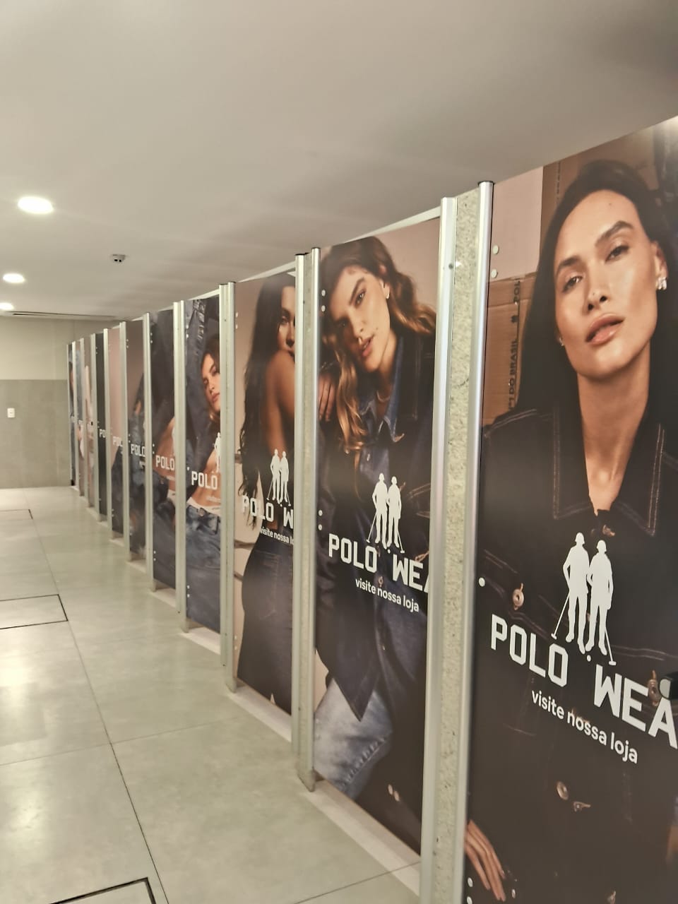 Tapume Polo Wear — adesivação modular em obra de loja