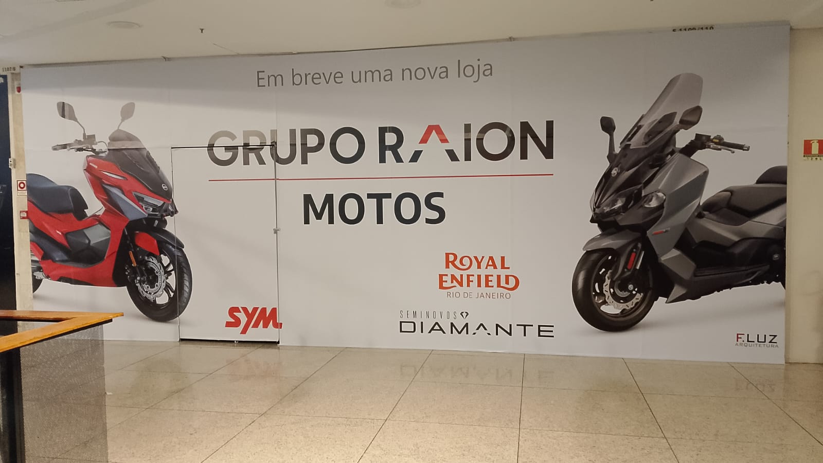 Tapume Grupo Raion Motos — adesivação de fachada de loja com Royal Enfield e SYM