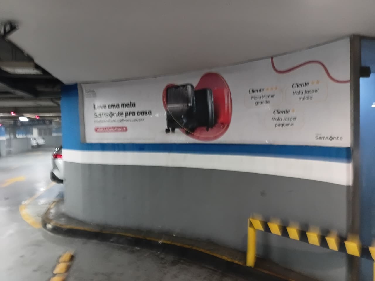 Adesivação curva em estacionamento Plaza Shopping — campanha Samsonite em parede semicircular