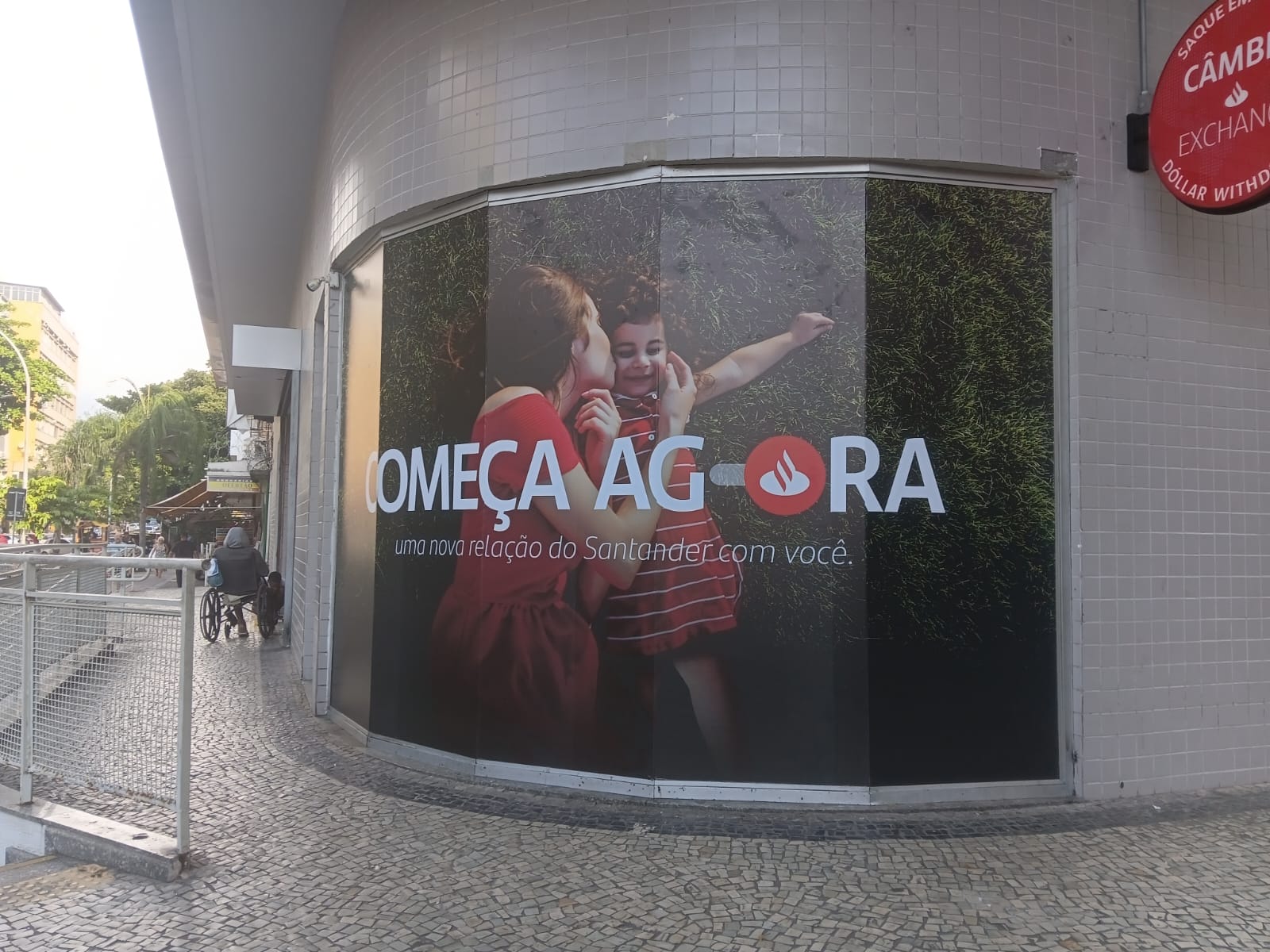 Envelopamento de fachada Santander Começa Agora — adesivação curva em agência bancária