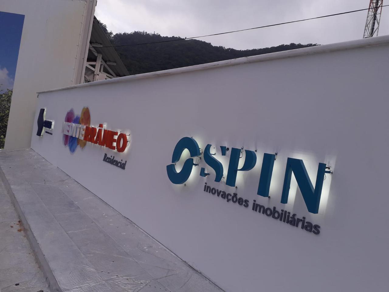 Muro de obra Mediterrâneo / Spin Inovações Imobiliárias — letras caixa com backlight