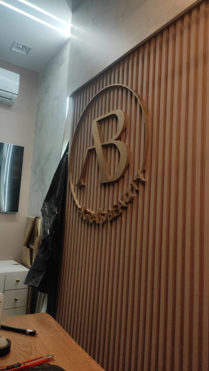 Logotipo AB Beauty em recorte sobre painel ripado — recepção