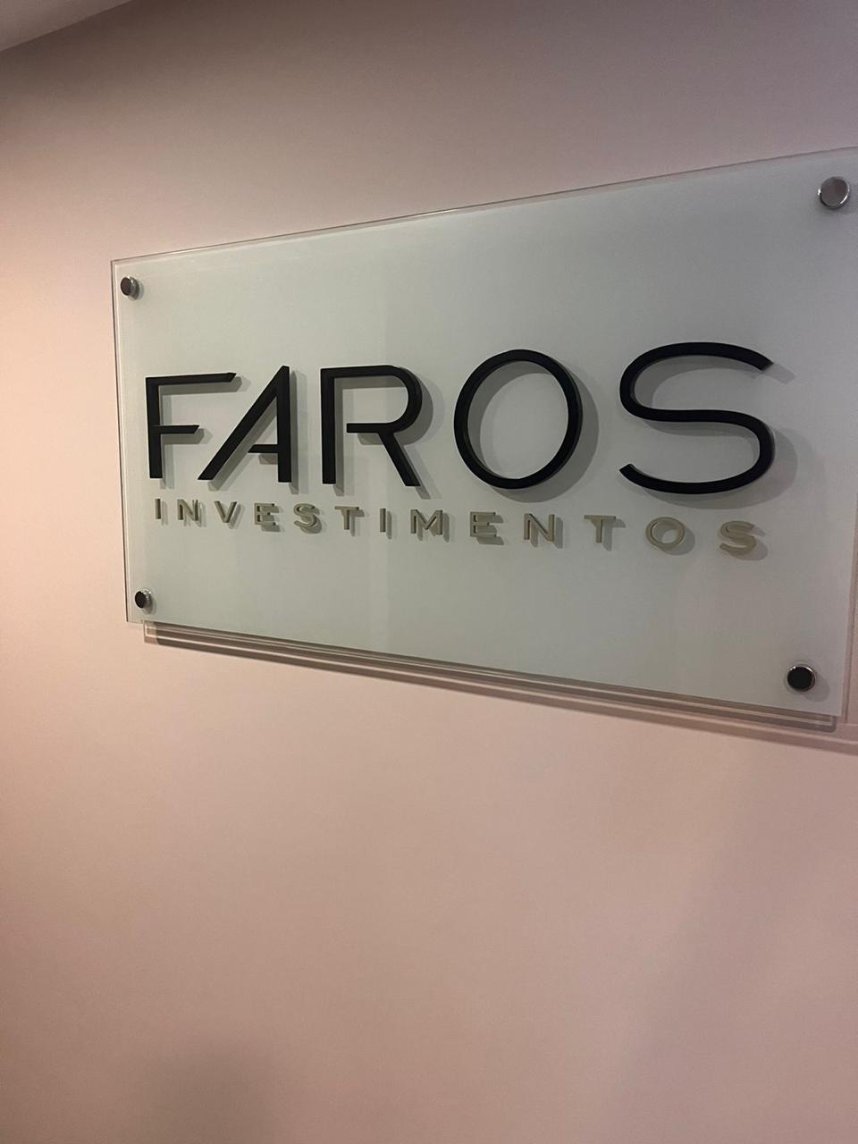 Placa institucional Faros Investimentos — vidro e letras em relevo