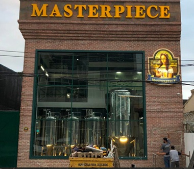 Fachada cervejaria Masterpiece — letreiro iluminado e logo redondo