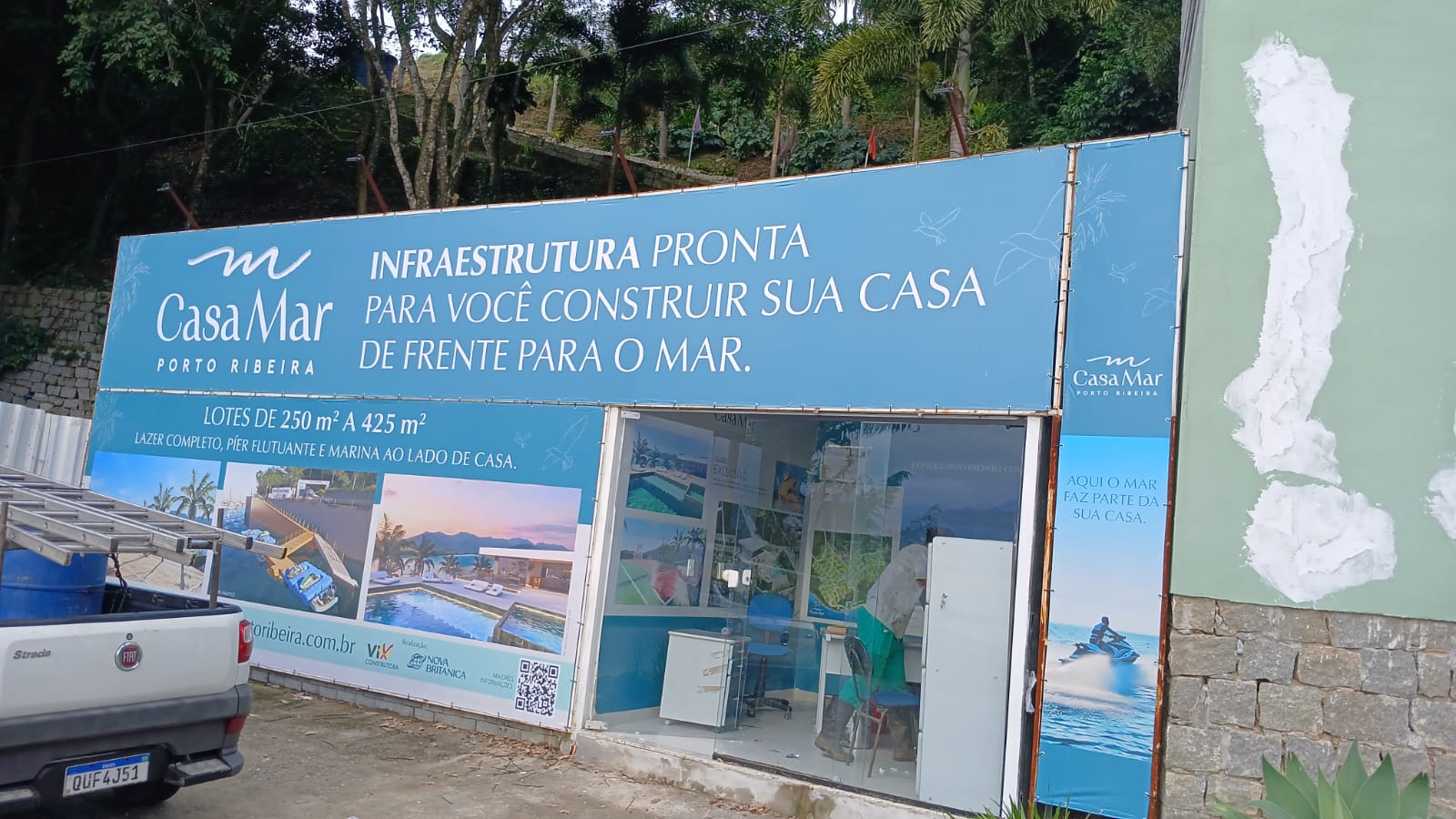 Painel publicitário CasaMar Porto Ribeira — fachada de stand de vendas com lonas integradas