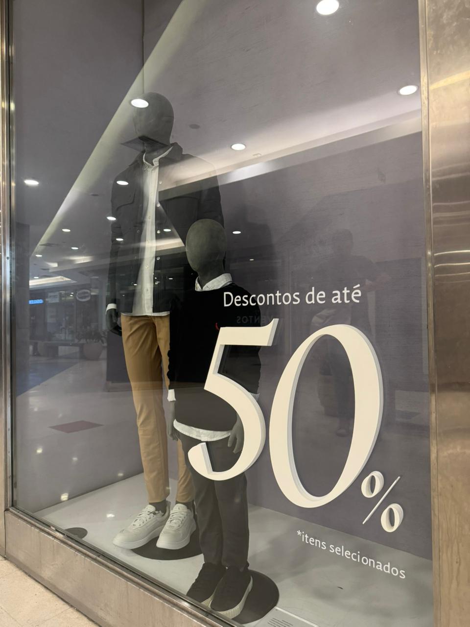 Vitrine de campanha Descontos de até 50% — letras em relevo e adesivação de fundo
