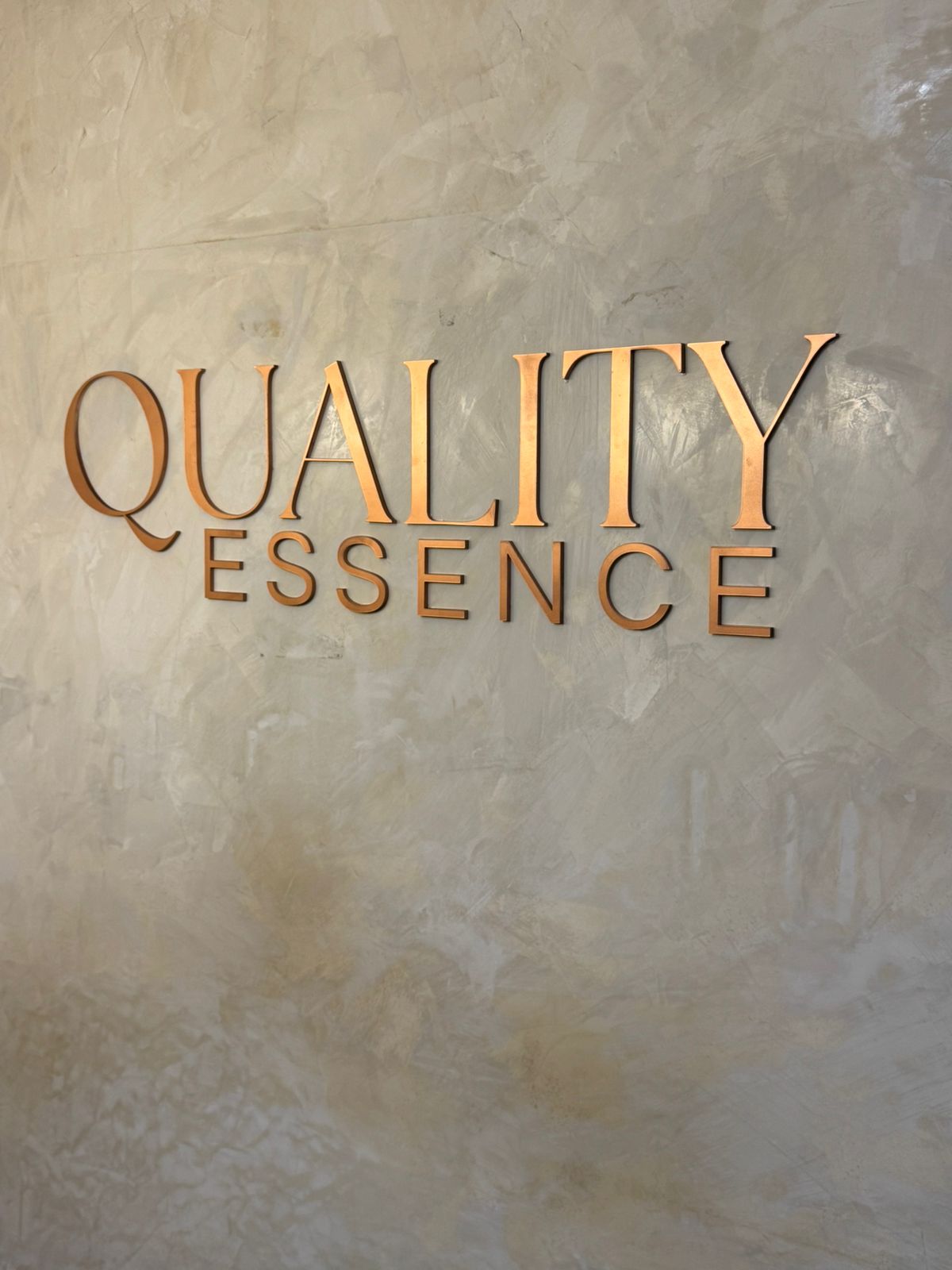 Letras recortadas em metal Quality Essence — parede em cimento queimado