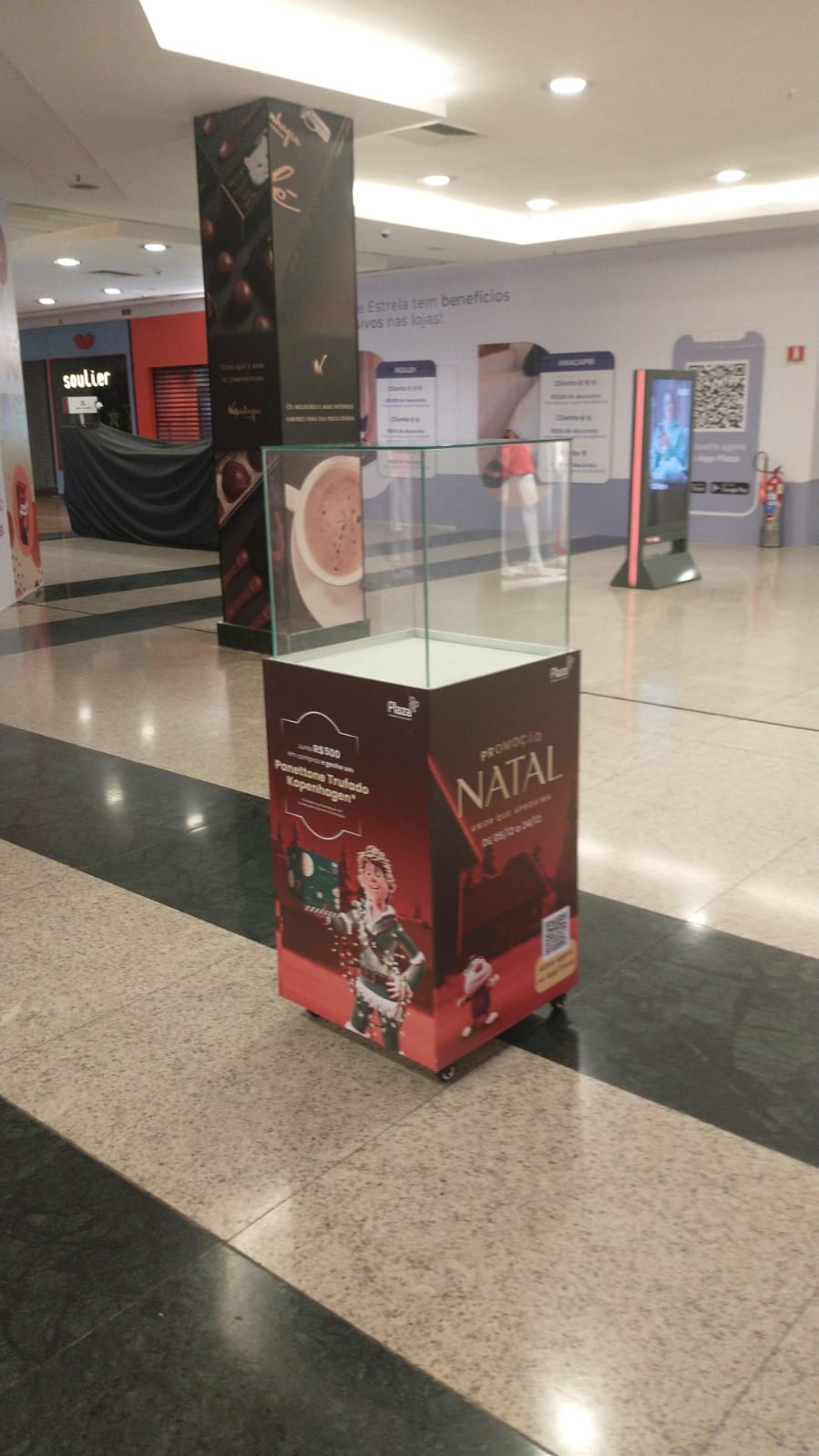 Totem promocional Kopenhagen Natal — pedestal com vitrine acrílica e adesivação Plaza Shopping