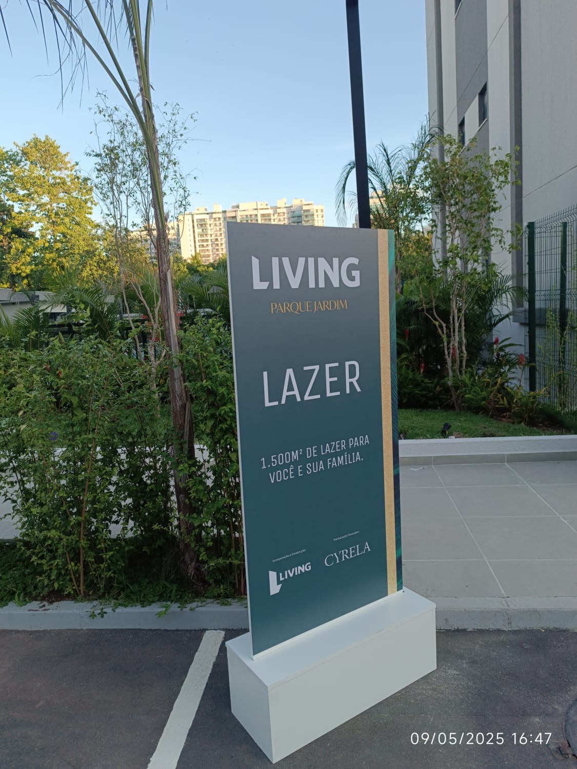 Totem institucional Living Parque Jardim Lazer — pedestal vertical com identidade visual Cyrela em área externa